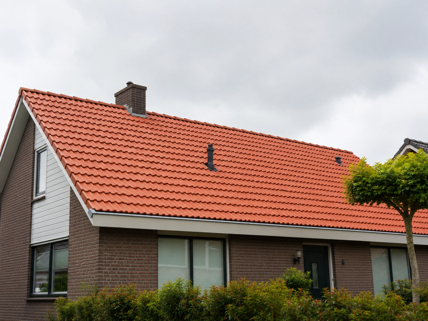 Groot rood pannendak van een gerenoveerde woning